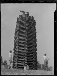 Two young boys look at the wooden structure to be used for a bonfire