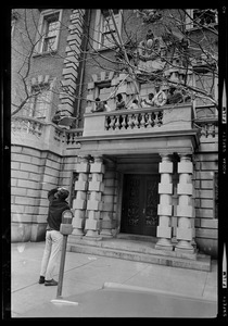 Sympathizer points to Black students on small balcony over entrance to Administration Building at Boston University