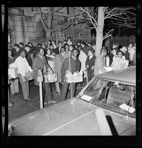 Groups of people with provision boxes walking out of the Boston University Administration Building as their 12 hour sit-in ends