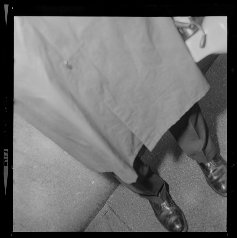 View of man in a trench coat and shoes