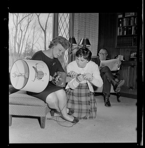 Marjorie Hall Brown and daughter, Marjorie, look at a lamp while husband and father, Walter Brown, sits in a chair
