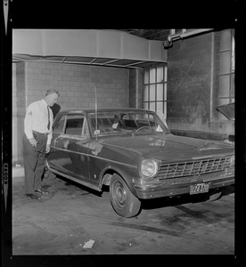 Sgt. Fred J. Balbini checks car used in jail break at Division 4 garage in South End