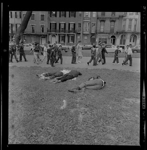 Three people laying down in the grass of Boston Common