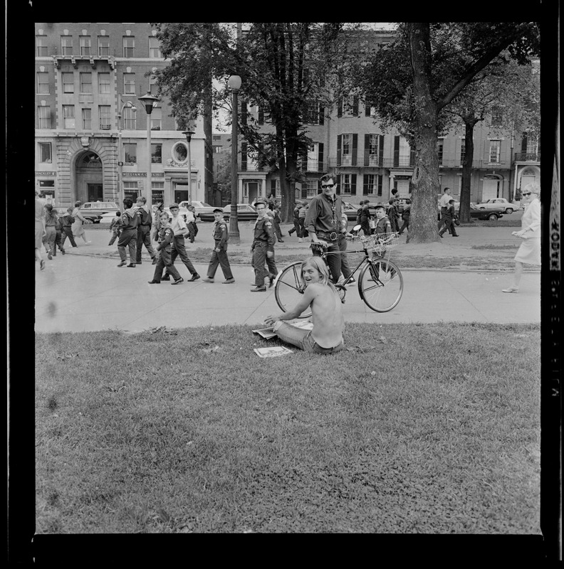 A man looks back to the camera as an officer on a bike stops