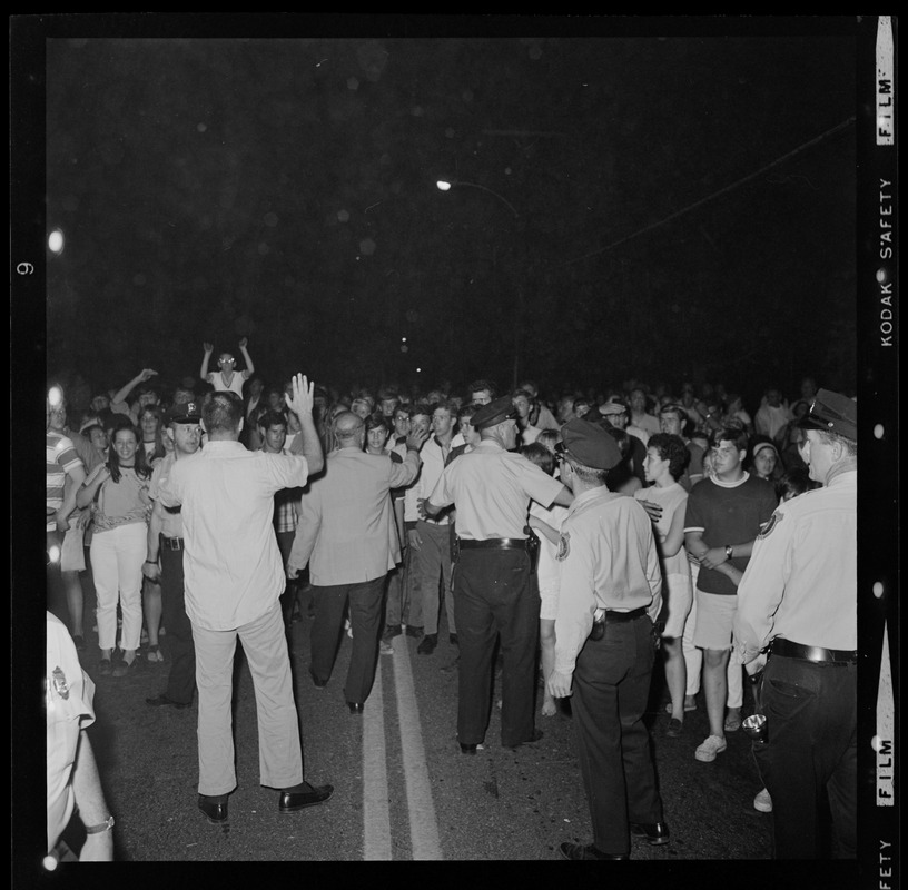 Policeman watching crowds gather in a street