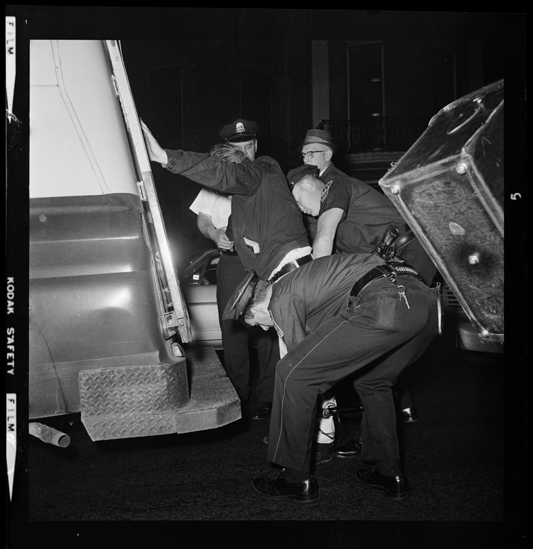 Police officers patting down a man