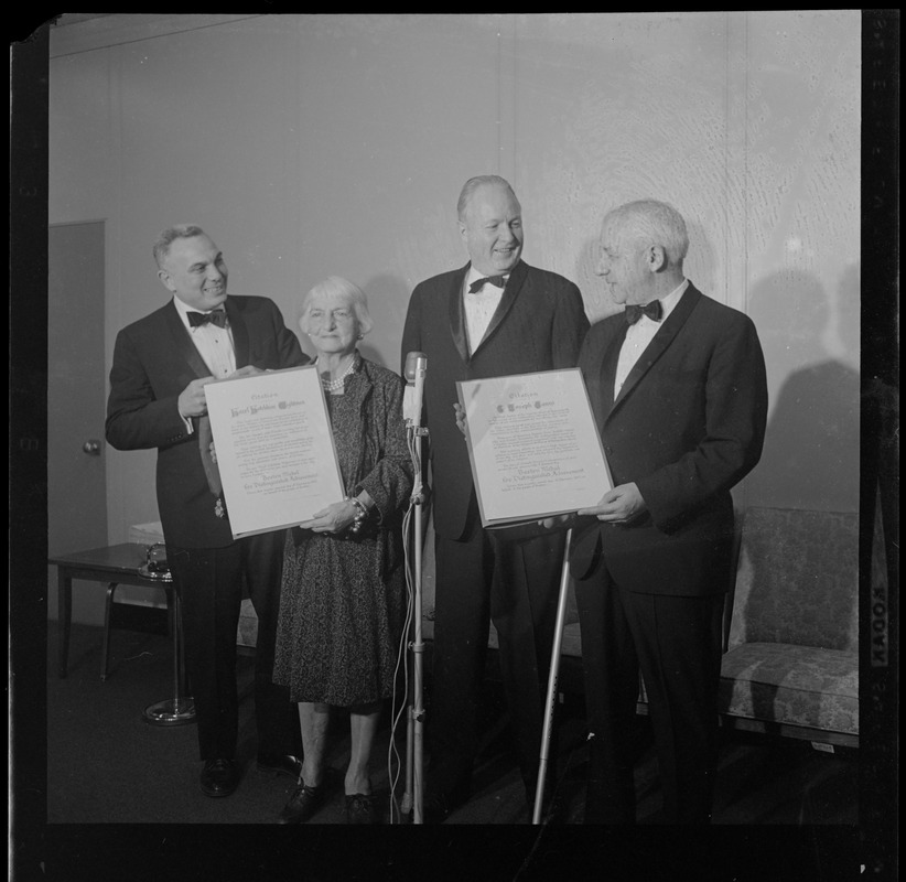 Hazel Hotchkiss Wightman and Justice G. Joseph Tauro holding Boston Medal for Distinguished Achievement awards and standing with Mayor Collins, middle, and one other man