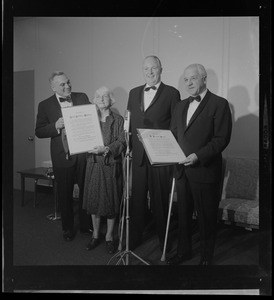 Hazel Hotchkiss Wightman and Justice G. Joseph Tauro holding Boston Medal for Distinguished Achievement awards and standing with Mayor Collins, middle, and one other man