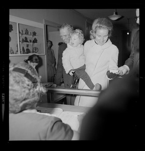 Mayor and Mrs. White have their hands full as they vote at Charles Street Meeting House, Beacon Hill