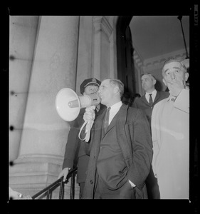 Kevin White using a megaphone to talk outside a building