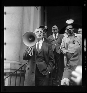 Kevin White using a megaphone to talk outside a building