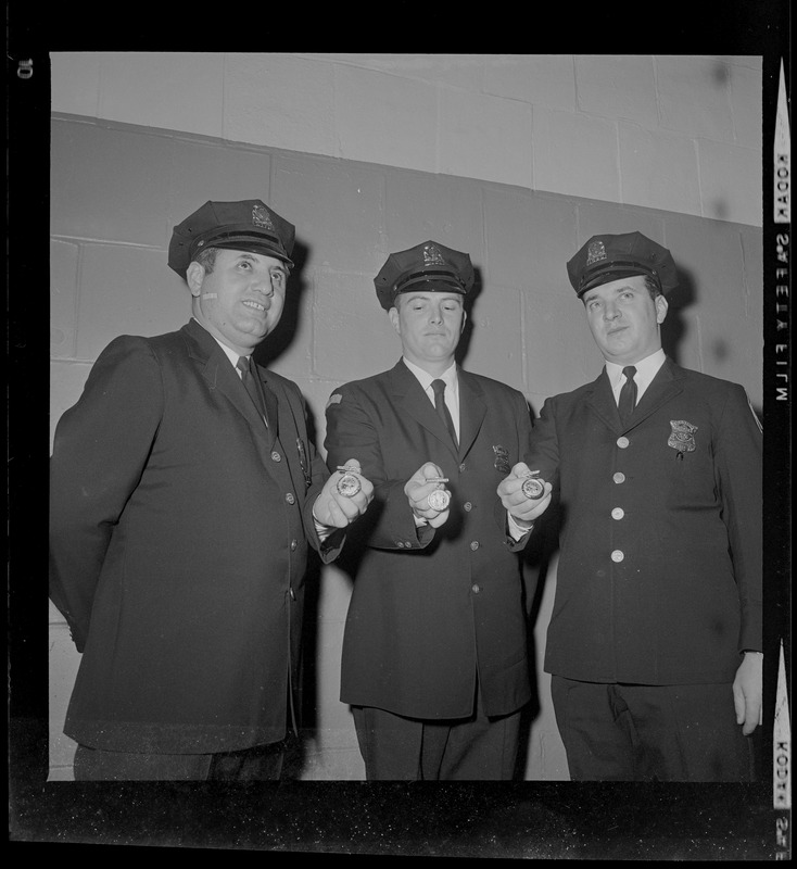 Three patrolman at the Policemen's Ball holding their Department Medals