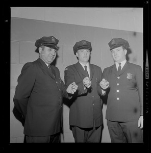 Three patrolman at the Policemen's Ball holding their Department Medals