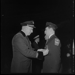 Police official pins a medal onto another police officer's jacket