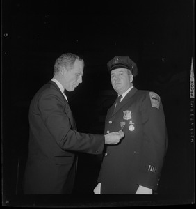 Mayor-Elect Kevin White pins the Walter Scott Medal of Honor on Ptl. Edward J. Phelan at Policemen's Ball