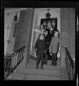 Kevin and Kathryn White standing with their four children by the front door of their home