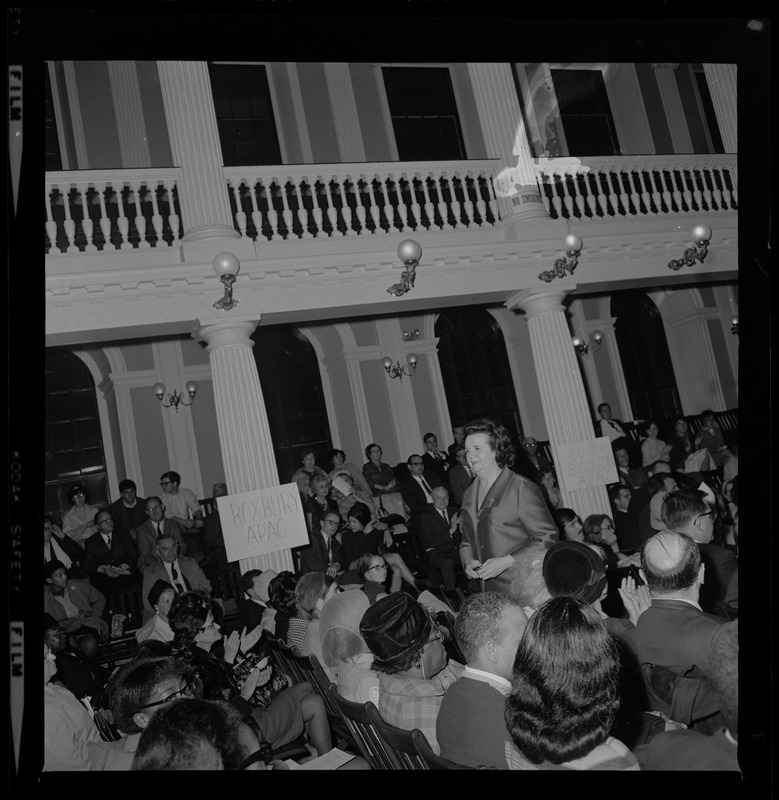 Louise Day Hicks walking through the crowd in the Great Hall of Faneuil Hall