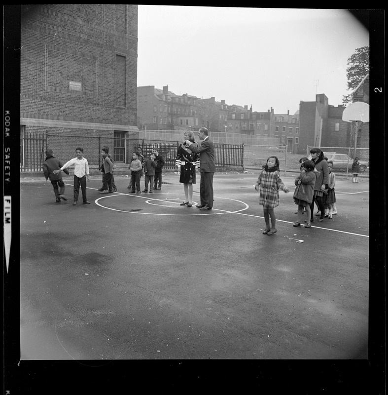 Kevin White with a woman and children on the basketball court