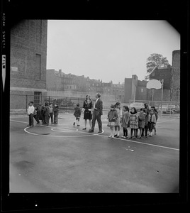 Kevin White with a woman and children on the basketball court