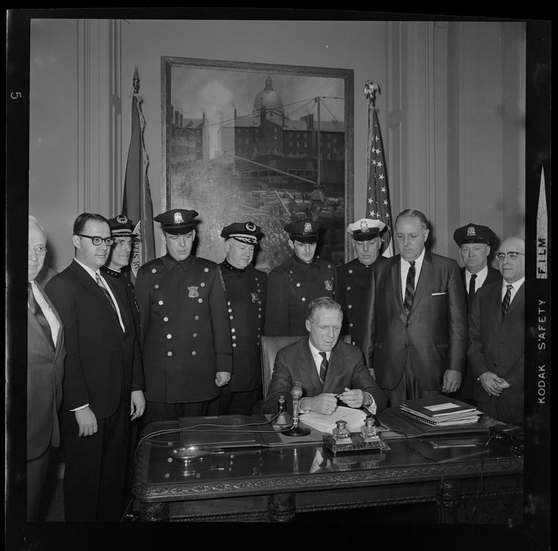 Mayor Kevin White at his desk signing Boston Police salary bill with