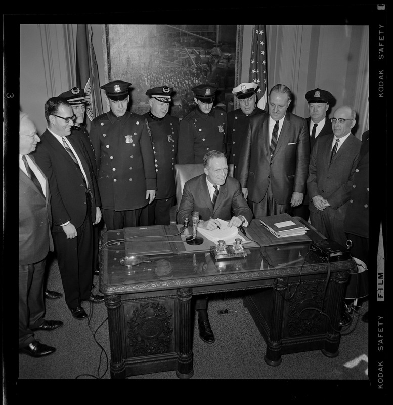Mayor Kevin White at his desk signing Boston Police salary bill with