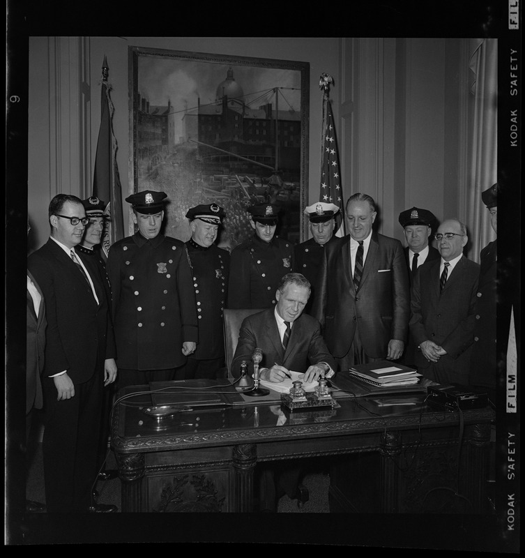 Mayor Kevin White at his desk signing Boston Police salary bill with