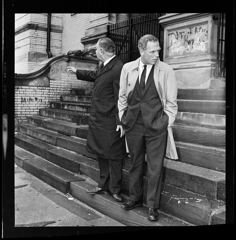 Mayor Kevin White on the front steps of South Boston High School, with graffiti on the walls