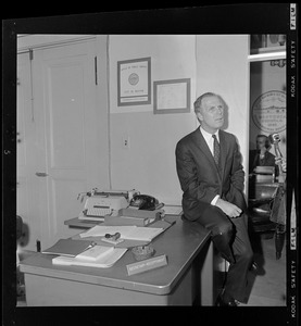 Mayor Kevin White sitting on a desk in City Hall