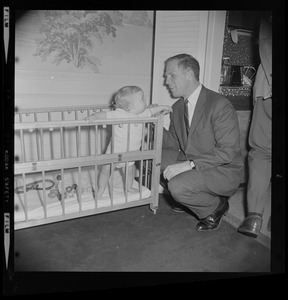 Kevin White kneels to son Christopher in his play pen