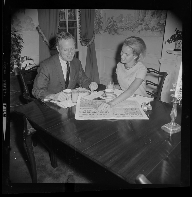 Kevin and Kathryn White looking through the Record American with the headline Hicks, White win