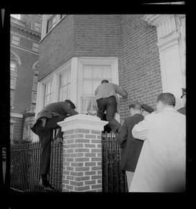 Officers climbing over a fence