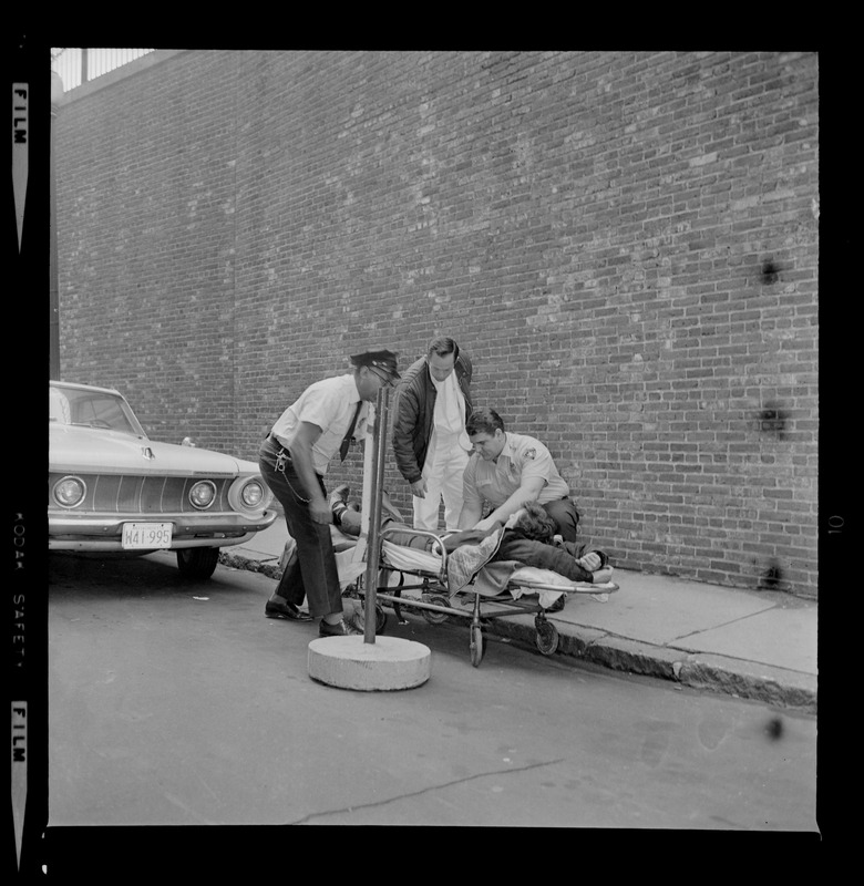 Officers placing an escaped prisoner Robert Barry on a stretcher