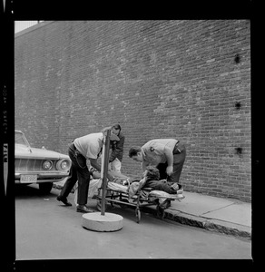 Officers placing an escaped prisoner Robert Barry on a stretcher