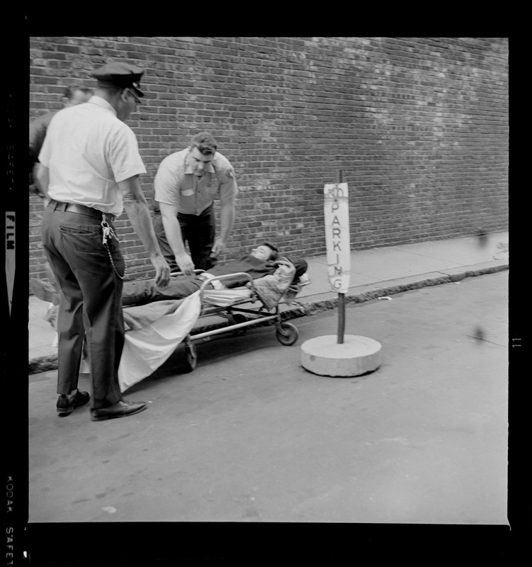 Officers placing an escaped prisoner Robert Barry on a stretcher