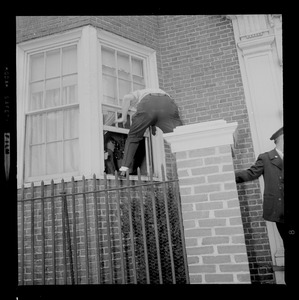 An officer climbing into a window