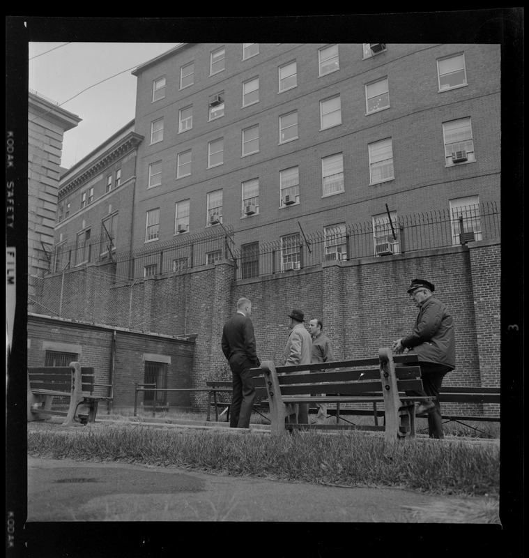 Officers talking near a bench in prison yard