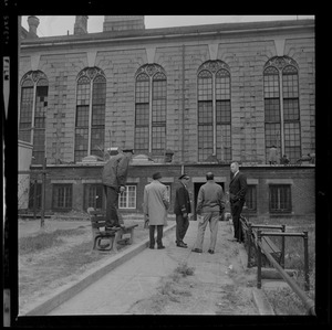 Officers talking near a bench in prison yard