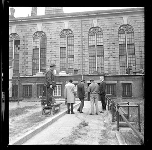 Officers talking near a bench in prison yard