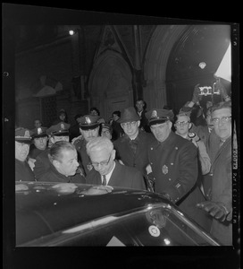 Arthur Goldberg surrounded by officers and entering a car