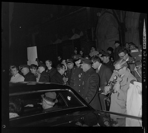 Arthur Goldberg seated in the back of a car that is surrounded by a crowd of people