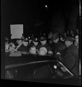 Arthur Goldberg surrounded by officers and entering a car