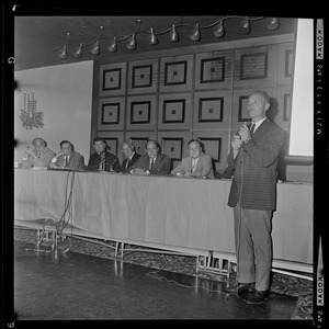 Man with microphone in hand addressing the room at Hotel Somerset