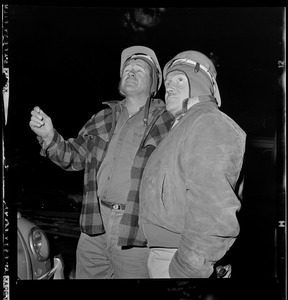 Awed looking but safe, steel workers Alfred Terrence (L.) and Henri Fortin observe wreckage of Bridge where moments before they escaped death by inches