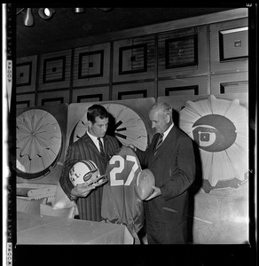 Joe Bellino with Patriots' president Bill Sullivan holding a jersey, helmet, and football after signing a contract with the Patriots the previous day
