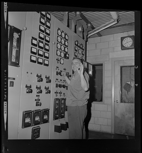 Technician in front of a power plant instrument and control panel