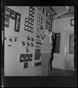 Technician in front of a power plant instrument and control panel