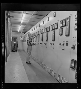 Man in front of a power plant instrument and control panel