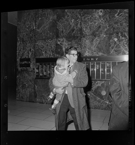 Man with small child in a building lobby
