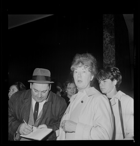 Man taking notes, most likely a reporter, from two women
