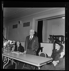 Man at a table addressing a room